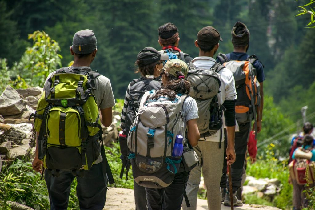 A diverse group of friends on a hiking trail, showcasing backpacking and outdoor adventure in a scenic forest.